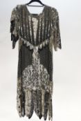 A 1920's style ladies evening dress with silver sequins and beads on a black ground,