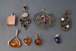 A collection of eight white metal pendants, some stamped "925",