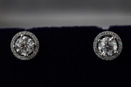 A pair of white metal single stone studs (approximately 1.