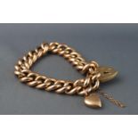 A yellow metal hollow curb link bracelet with padlock clasp and safety chain.