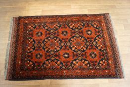 A 20th century rug with overall repeating design within three borders,