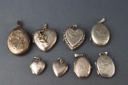 A collection of eight silver and white metal lockets, four in the form of hearts and four oval,