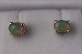 A pair of silver and natural Ethiopian opal studs. Approximately 1.