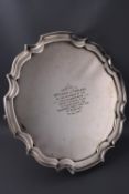 A silver salver with pie crust border on three scroll feet,