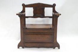 An oak Art Deco two armed hall bench with lift u[ seat,