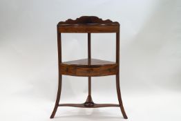 A George III mahogany three tier corner wash stand with drawer to centre,