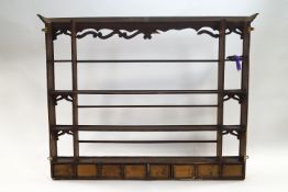 A 19th century pine hanging rack with eight drawers below two shelves,