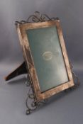 A silver photograph frame, of rectangular form with wirework crest and feet, overall 20cm high,