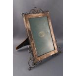 A silver photograph frame, of rectangular form with wirework crest and feet, overall 20cm high,