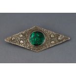 An Arts and Crafts brooch with white metal textured mount and green resin centre 11.
