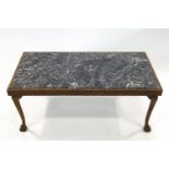 An early 20th century oak and marble top coffee table on carved ball and claw feet,