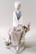 A Lladro porcelain figure of a seated girl with a bird upon a branch, 25cm high,