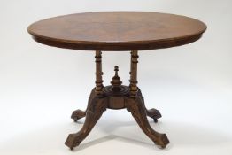 A walnut loo table on carved pedestal and legs,
