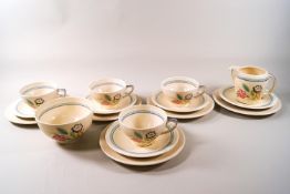 A 1940's Susie Cooper part tea set with flower decorations comprising of four cups and five saucers,