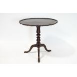 A George III style mahogany tripod table, the top with piecrust edge, on turned column and pad feet,