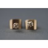 A pair of white metal single stone diamond stud earrings. Approx 0.15ct total diamond weight.