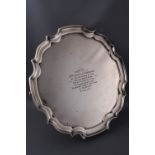 A silver salver with pie crust border on three scroll feet,