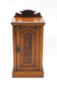 A Victorian mahogany pot cupboard, with raised back above a panelled door.