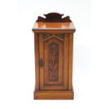 A Victorian mahogany pot cupboard, with raised back above a panelled door.