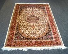 A Keshan style rug with central motif and all over flower decoration within three alternating