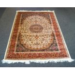 A Keshan style rug with central motif and all over flower decoration within three alternating