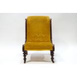 A Victorian mahogany button back nursing chair with scroll detail to frame,