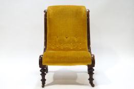 A Victorian mahogany button back nursing chair with scroll detail to frame,