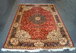 A Bokhara machine woven carpet with repeating design within multiple borders on a red ground,