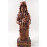 A 20th century carved wood figure of a man wearing a crown and holding a child,