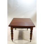 A Victorian mahogany extending dining table with single leaf on turned legs,