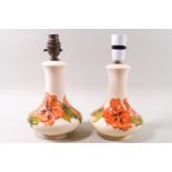 A pair of Moorcroft table lamps, hibiscus pattern on a cream ground, impressed factory marks,