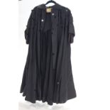 A ladies black evening coat with black circular disks,