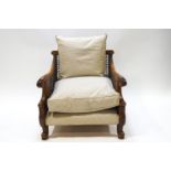 A carved hardwood Bergere armchair with acanthus motif arms raised on scrolled legs 75 cms