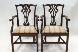 A pair of George III style mahogany elbow chairs with pierced splats,