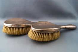 A pair of silver backed hair brushes,