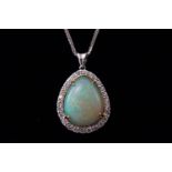 A white metal opal and diamond cluster pendant. Having a pear cut cabochon opal.