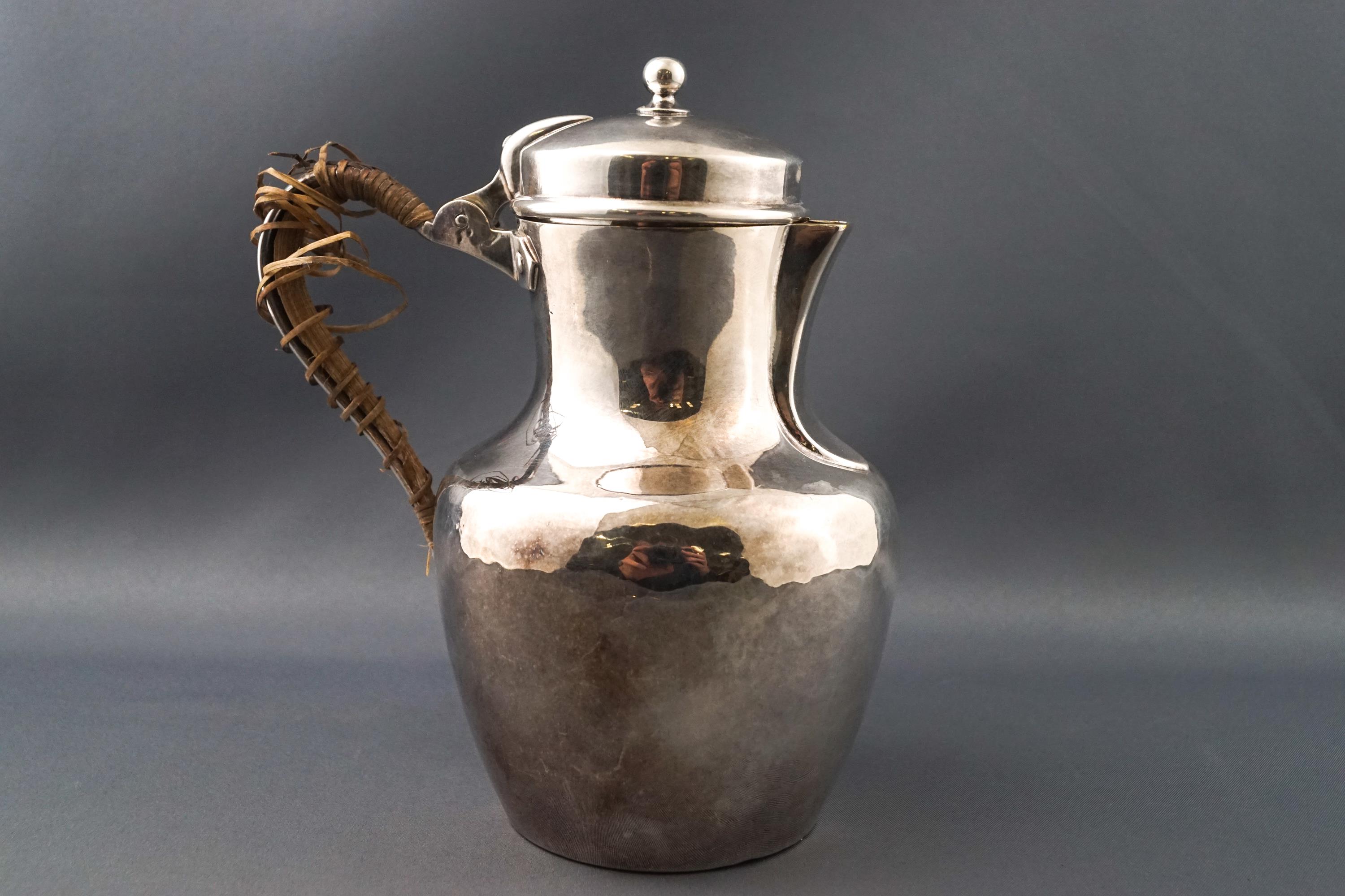 A white metal jug by Christofle, of baluster form with domed lid.