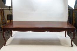 A large French style mahogany dining table with shaped apron on cabriole legs,