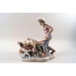 A Lladro porcelain figure of a boy collecting hay with his dog,