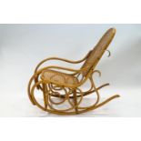 A 20th century bentwood rocking chair with caned back and seat