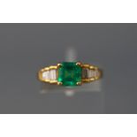 A yellow metal dress ring set with a square emerald.