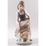 A Lladro porcelain figure of a girl with a cat at her feet.