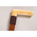 A Malacca shafted walking stick with late Victorian ivory handle and leather collar
