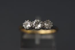 A yellow and white metal three stone diamond ring set with transitional cut diamonds.