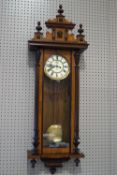 A Gustav Becker Vienna wall clock, the mixed hardwood case with a shaped cresting,