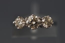 A white metal three stone diamond ring.