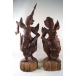 A pair of carved Balinese figures of dancers, in traditional costume, 65cm high,