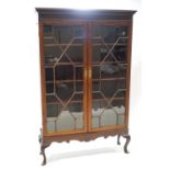 A mahogany standing display cabinet with blind fret cornice with astragal glazed doors over a