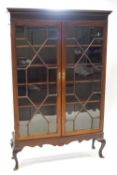 A mahogany standing display cabinet with blind fret cornice with astragal glazed doors over a
