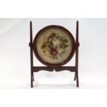 A mahogany framed fire screen with woolwork and carpet work panel,